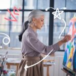 Woman creating colorful abstract wall art in a studio