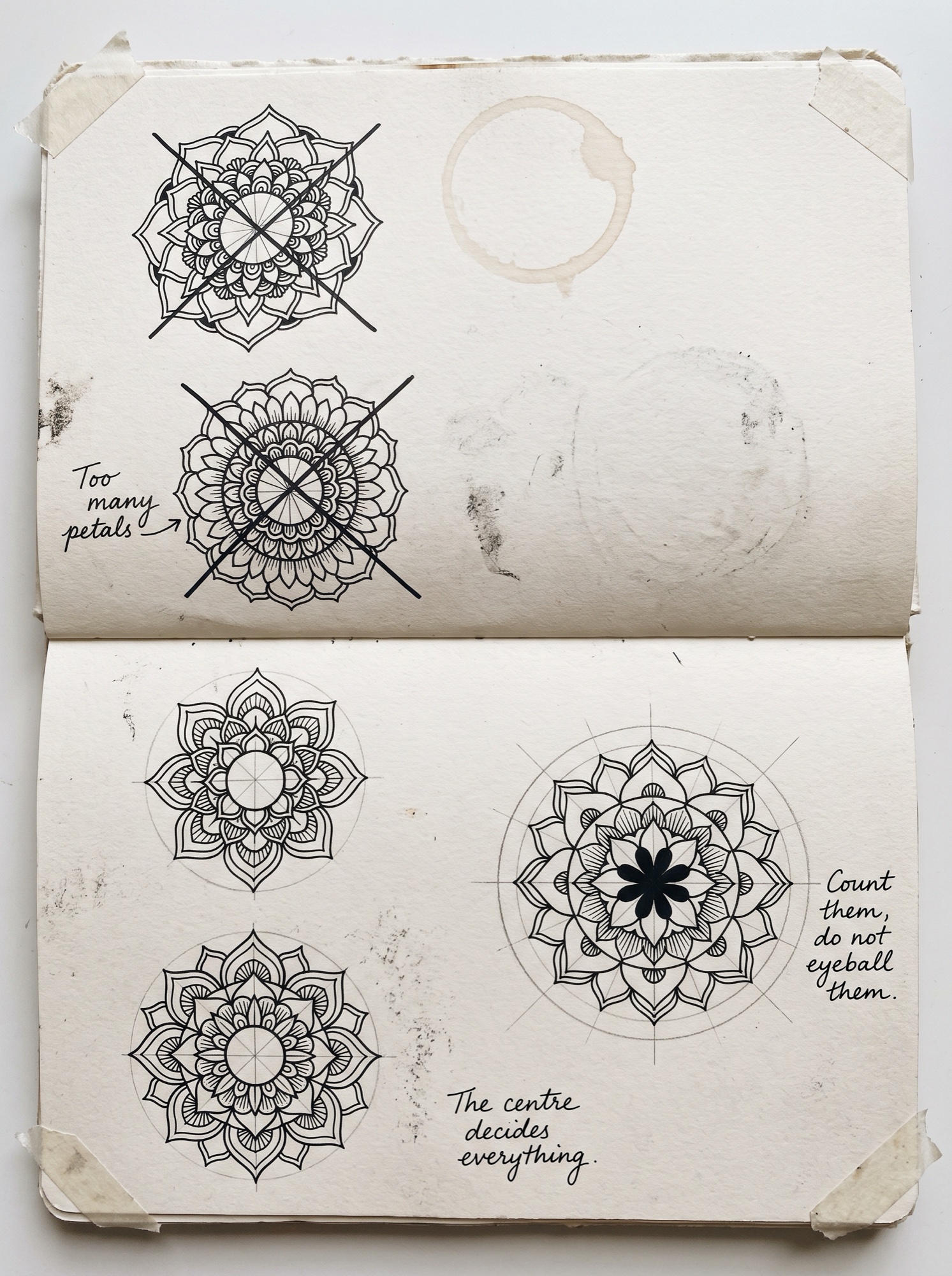 Artist journal page of mandala attempts with faint construction circles and margin notes