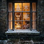 Christmas window painting ideas: a lit sash window painted with a fir, a star and a stag, seen from the snowy street