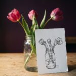 How to draw flowers in a vase: a glass jam jar of three tulips beside an ink drawing of the same bouquet with one bloom turned away