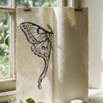 Luna moth drawing on a folded sheet standing upright, the left wing finished in ink and the right half still bare paper